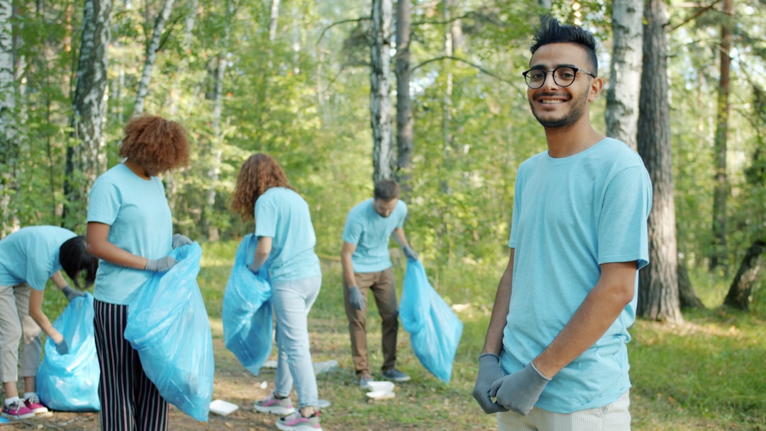 Volunteers cleaning a park with blue trash bags